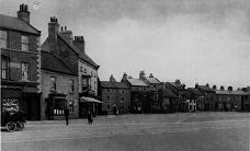 College Square, showing what is now Trevor's Fish and Chip shop, and Y'Thai restaurant. There is a motorised vehicle outside what is now SPAR